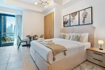 a bedroom with a large bed and a balcony at Luxury JLT Studio Lake View Metro Pool Access in Dubai