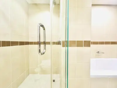 a shower with a glass door in a bathroom at Venduras- Chic 1BR Getaway near Burj Khalifa in Dubai