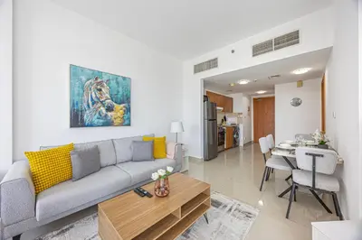 a living room with a couch and a table at Chic 1BR Retreat with Lake Views & Modern Comforts in Dubai