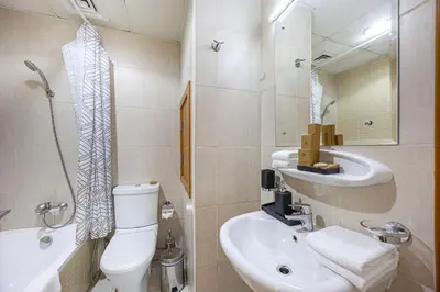 a bathroom with a toilet and a sink and a mirror at Chic 1BR Retreat with Lake Views & Modern Comforts in Dubai