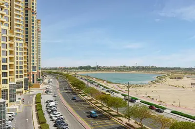 a view of a city street with a beach and buildings at Chic 1BR Retreat with Lake Views & Modern Comforts in Dubai