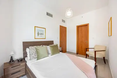 a bedroom with a bed and a desk and a chair at Chic 1BR Retreat with Lake Views & Modern Comforts in Dubai