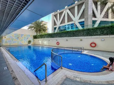 a large pool with blue water in a building at Chic Marina Arcade Apartment Minutes to Beach in Dubai