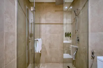 a bathroom with a shower with a glass door at Chic Marina Arcade Apartment Minutes to Beach in Dubai