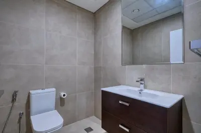 a bathroom with a toilet and a sink and a mirror at Chic Marina Arcade Apartment Minutes to Beach in Dubai
