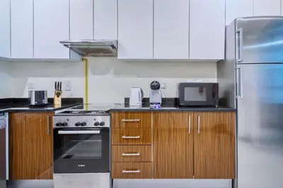 a kitchen with a stove and a refrigerator at Chic Marina Arcade Apartment Minutes to Beach in Dubai