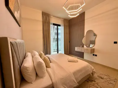 a bedroom with a bed with pillows and a mirror at Smart & Stylish 1BHK With Keyless Entry! in Dubai