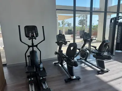 a gym with several tread machines in a room at Cozy studio Pet Friendly Pool, Gym, Water Near Downtown in Dubai