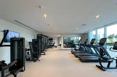 a gym with rows of treadmills and elliptical machines at Mahogany 11 - 2BR 10 Guests - Walk to Burj Khalif in Dubai