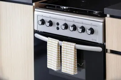a black and white oven with towels hanging from it at Mahogany 12 - 2BR 10 Guests - Walk to Burj Khalifa in Dubai