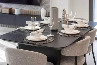 a black table with plates and wine glasses on it at Mahogany 12 - 2BR 10 Guests - Walk to Burj Khalifa in Dubai