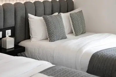 a bedroom with two beds with white sheets and pillows at Mahogany 12 - 2BR 10 Guests - Walk to Burj Khalifa in Dubai