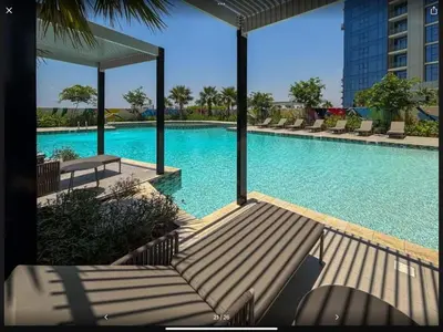 a large swimming pool with chairs and a building at Samani vacation homes 3108 canal view in Dubai