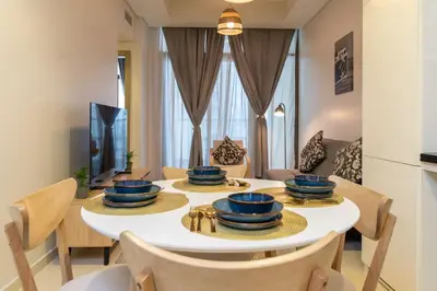 a dining room with a white table and chairs at Samani vacation homes 3108 canal view in Dubai