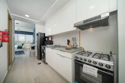 a kitchen with a stove and a sink at Spacious JVC Studio Luxury Escape in Dubai