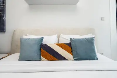 a bed with a bunch of pillows on it at Spacious JVC Studio Luxury Escape in Dubai