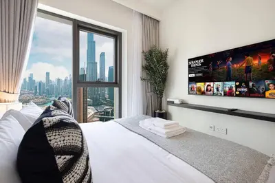 a bedroom with a large window and a tv on the wall at Mahogany 14 - 2BR Dubai Mall Walk & Burj Khalifa in Dubai