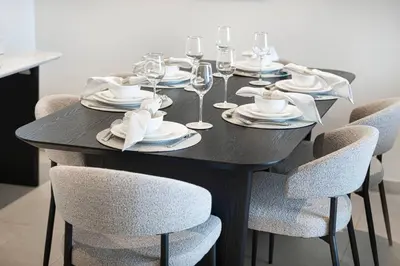 a black table with chairs and plates and wine glasses at Mahogany 14 - 2BR Dubai Mall Walk & Burj Khalifa in Dubai