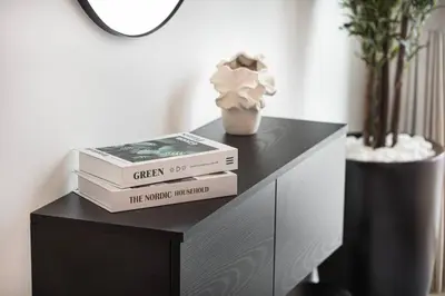 a stack of books sitting on top of a dresser at Mahogany 14 - 2BR Dubai Mall Walk & Burj Khalifa in Dubai