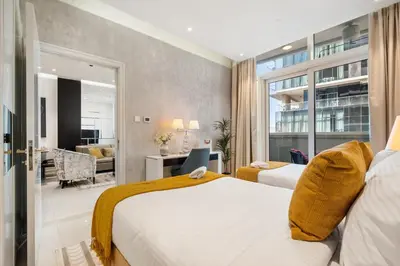 a hotel room with two beds and a living room at Nice 2 Bedroom Apartment! 5 Minutes walk to Dubai Mall, Downtown Dubai in Dubai