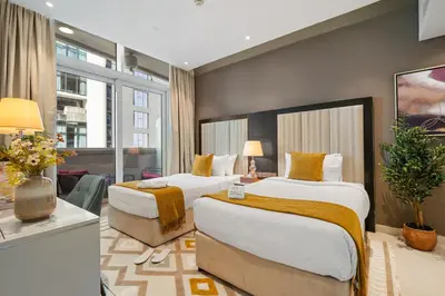 a hotel room with two beds with yellow pillows at Nice 2 Bedroom Apartment! 5 Minutes walk to Dubai Mall, Downtown Dubai in Dubai