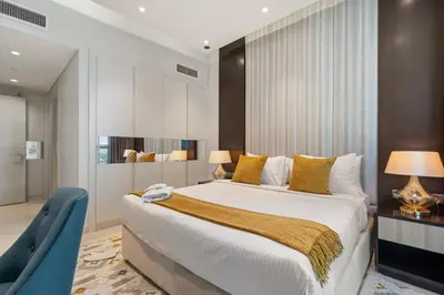 a bedroom with a large bed and a blue chair at Nice 2 Bedroom Apartment! 5 Minutes walk to Dubai Mall, Downtown Dubai in Dubai