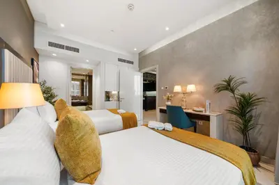 a hotel room with two beds and a desk at Nice 2 Bedroom Apartment! 5 Minutes walk to Dubai Mall, Downtown Dubai in Dubai