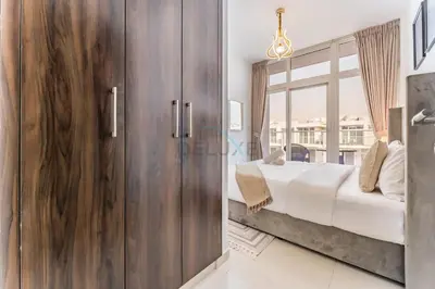 a bedroom with a bed and a large window at Community and Pool View 3BR Townhouse, Minutes from Desert Camp,DAMAC Hills 2 Amargo by Deluxe Holiday Homes in Dubai