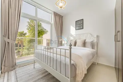 a white bedroom with a bed and a large window at Community and Pool View 3BR Townhouse, Minutes from Desert Camp,DAMAC Hills 2 Amargo by Deluxe Holiday Homes in Dubai