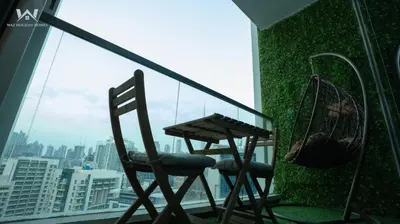 two chairs and a table on the balcony of a building at Elevated Living Studio Facing the Burj in Dubai