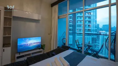 a bedroom with a bed and a large window at Elevated Living Studio Facing the Burj in Dubai