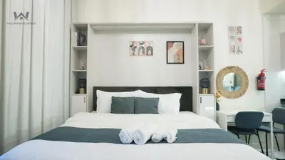 a bedroom with a bed with two white slippers on it at Elevated Living Studio Facing the Burj in Dubai