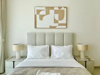 a bedroom with a large bed with two lamps at Opulent Nook 1br Designer Hideaway In Onyx in Dubai