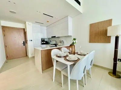 a kitchen and dining room with a table and chairs at Opulent Nook 1br Designer Hideaway In Onyx in Dubai