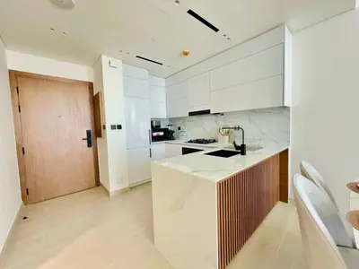 a kitchen with white cabinets and a counter top at Opulent Nook 1br Designer Hideaway In Onyx in Dubai