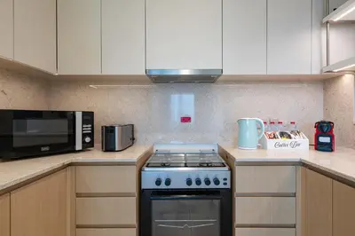 a kitchen with a stove and a microwave at Downtown Dubai 3BR Burj Royale in Dubai