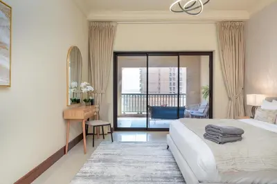 a bedroom with a bed and a desk and a balcony at Golden Mile at its Best 2BR Plus Maids Palm Jumeirah in Dubai