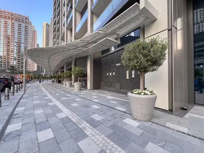 a sidewalk with potted plants and an awning on a building at Sky-High Burj Khalifa and Fountain Views in Dubai