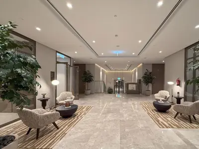 a lobby with chairs and plants in a building at Sky-High Burj Khalifa and Fountain Views in Dubai