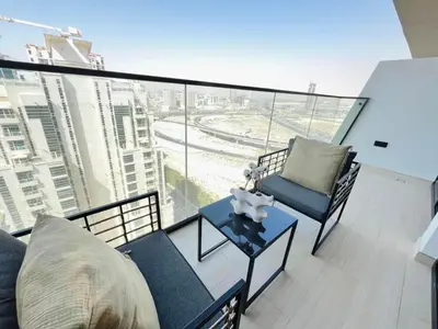 a balcony with two chairs and a table on a building at Comfortable 1br In Jvc Balcony Free Parking in Dubai