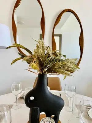 a black vase on a table with a plant in it at Comfortable 1br In Jvc Balcony Free Parking in Dubai