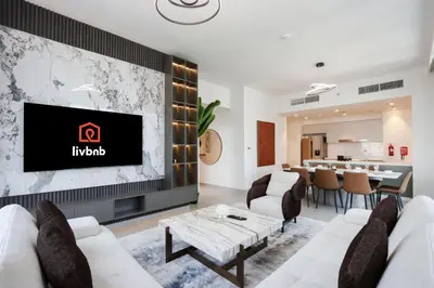 a living room with a tv on a wall at Upgraded 3BR plus Maid's near Burj Khalifa & Dubai Opera in Dubai