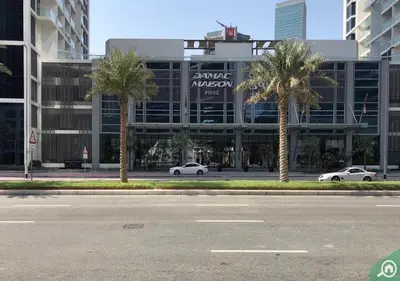 a building with palm trees in front of a street at Stunning Canal View with Balcony in Dubai