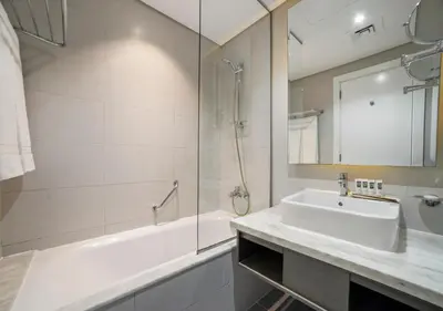 a bathroom with a sink and a shower and a tub at Stunning Canal View with Balcony in Dubai
