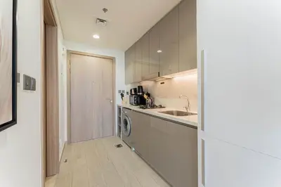 a kitchen with a sink and a washing machine at TRPS - Azizi Riviera 23, Al Meydan - Contemporary Studio in the Heart of Dubai in Dubai