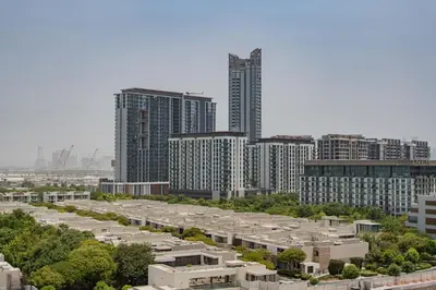 a large parking lot in a city with tall buildings at TRPS - Azizi Riviera 23, Al Meydan - Contemporary Studio in the Heart of Dubai in Dubai