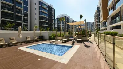 a swimming pool in the middle of a courtyard with buildings at TRPS - Azizi Riviera 23, Al Meydan - Contemporary Studio in the Heart of Dubai in Dubai