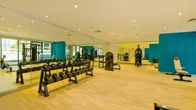 a gym with a row of treadmills and machines at TRPS - Azizi Riviera 23, Al Meydan - Contemporary Studio in the Heart of Dubai in Dubai