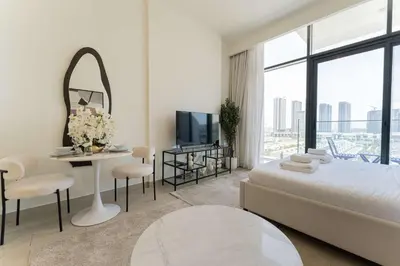 a bedroom with a bed and a table with a mirror at TRPS - Azizi Riviera 23, Al Meydan - Contemporary Studio in the Heart of Dubai in Dubai