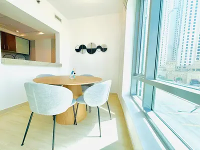 a dining room with a table and two chairs at Vserve - 1 BR Escape in the Heart of Dubai Marina in Dubai
